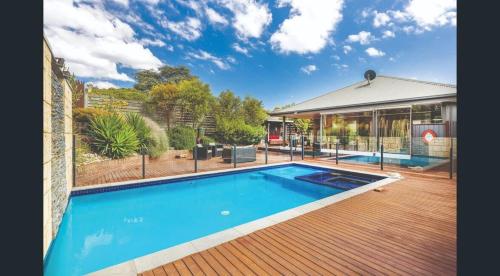 a house with a large swimming pool next to a building at The Great Entertainer in Rye w pool near the beach! in Rye