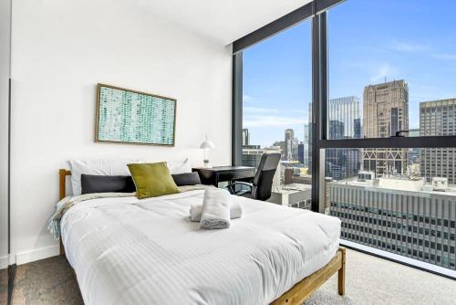 1 dormitorio con cama blanca y ventana grande en Collins House - Melbourne Cbd Amazing view, en Melbourne