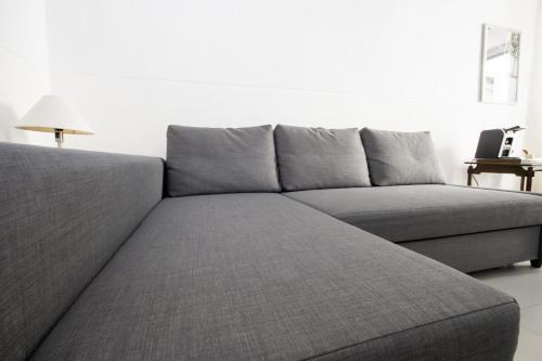 a grey couch in a living room with a lamp at Le Tre Sorelle in Bari