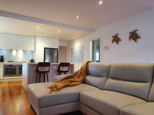 a living room with a couch and a kitchen at The Great Entertainer in Rye w pool near the beach! in Rye