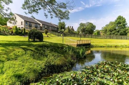 a house and a pond in front of a house at The House @ Sitwell Arms Hotel in Renishaw