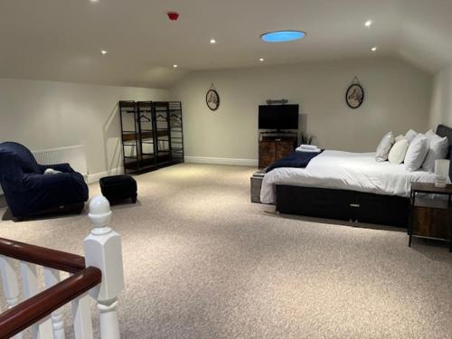 The House @ Sitwell Arms Hotel في Renishaw: غرفة نوم كبيرة بها سرير وكرسي