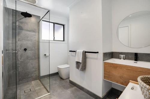a bathroom with a shower and a toilet and a sink at Invigorating Dromana Seaside Retreat w private spa in Dromana