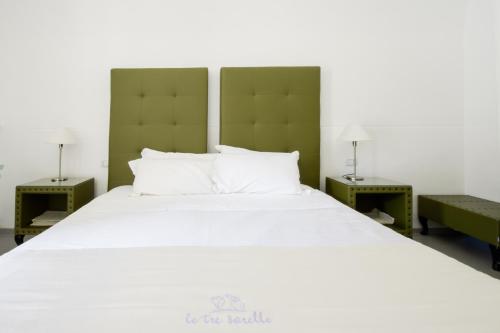 a bedroom with a large white bed with two tables at Le Tre Sorelle in Bari