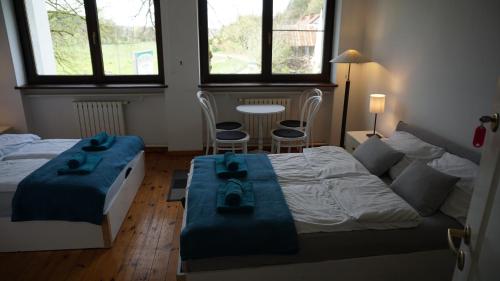 a bedroom with two beds and a table and two chairs at Pensjonat Kowalski in Łubowo