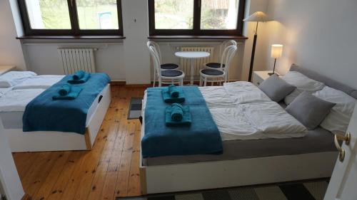 a bedroom with two beds with blue towels on them at Pensjonat Kowalski in Łubowo