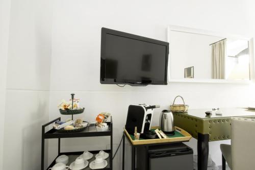 a living room with a tv on the wall and a kitchen at Le Tre Sorelle in Bari
