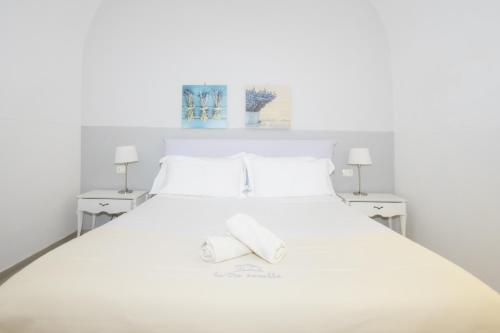 a white bed with two white towels on it at Le Tre Sorelle in Bari