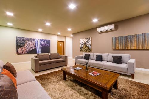 a living room with two couches and a coffee table at Hotel Laghetto Vivace in Canela