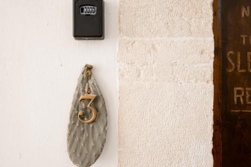 a clock hanging on a wall next to a door at Le Tre Sorelle in Bari