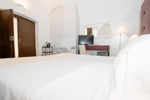 a bedroom with a white bed and a television at Le Tre Sorelle in Bari