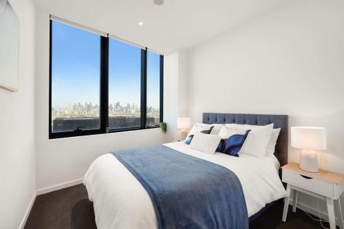 1 dormitorio con 1 cama grande y ventana grande en Victoria Square - Central Footscray InnerUrban Apt, en Melbourne