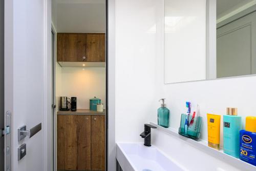 a bathroom with a sink and a mirror at Tiny Olav houseboat close to the beach and restaurants by Weltevreden Experience in Zeewolde