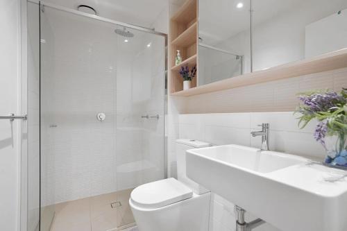 a bathroom with a toilet and a sink and a shower at Victoria Square - Central Footscray InnerUrban Apt in Melbourne