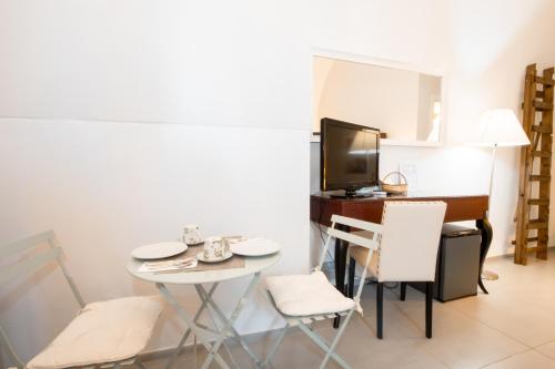 a small room with a table and chairs and a television at Le Tre Sorelle in Bari