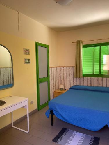 マリーナ・ディ・カスタニェート・カルドゥッチにあるHotel Lupo di mareのベッドルーム(ベッド1台、テーブル、鏡付)