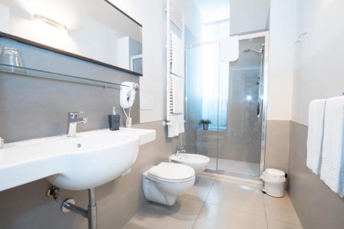 a white bathroom with a sink and a toilet at Le Tre Sorelle in Bari