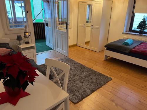 a living room with a table and a room with a bed at Wolke 7 in Freital
