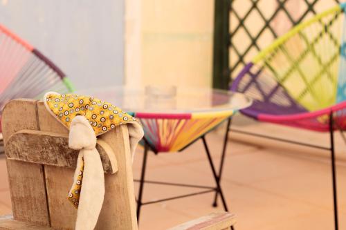 una mesa y una silla con una bufanda. en Hotel Camille, en Saintes-Maries-de-la-Mer