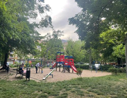 a playground with colorful play equipment in a park at Apartman Avenia in Novi Sad