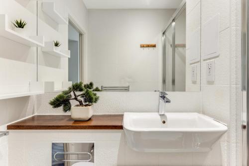 bagno bianco con lavandino e specchio di The Wandsworth Luxury Apartment a Londra