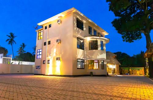a white building on a cobblestone street at Velmont Hotel in Dar es Salaam