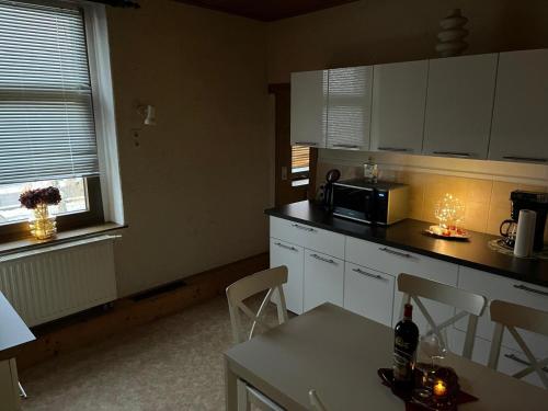 a kitchen with a microwave and a table with chairs at Wolke 7 in Freital