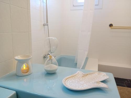 une table bleue avec une lampe et un vase sur elle dans l'établissement Bas de villa avec jardin piscine clim proche plages calanques, à Marseille