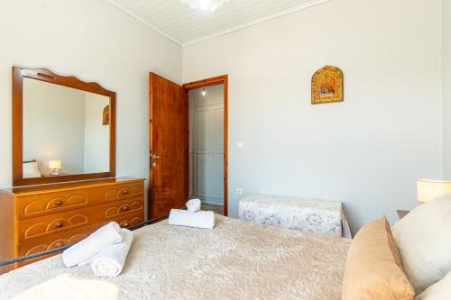 a bedroom with a bed with a dresser and a mirror at Victoria's House in Gaios