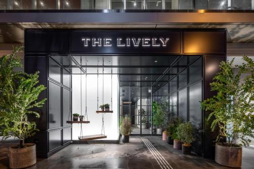 een toegang tot de lobby van een gebouw met potplanten bij THE LIVELY TOKYO AZABUJUBAN in Tokyo