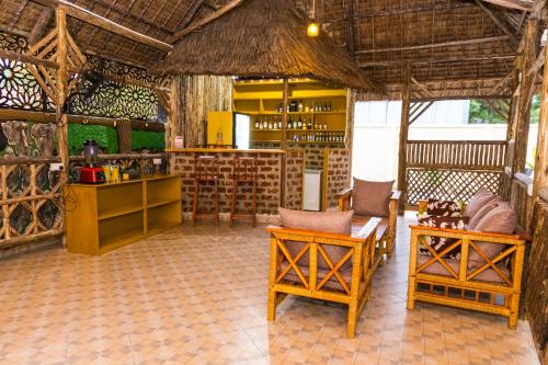um quarto com um bar e algumas cadeiras e mesas em Velmont Hotel em Dar es Salaam
