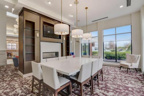 a dining room with a white table and chairs at Hilton Garden Inn Indianapolis Northwest in Indianapolis