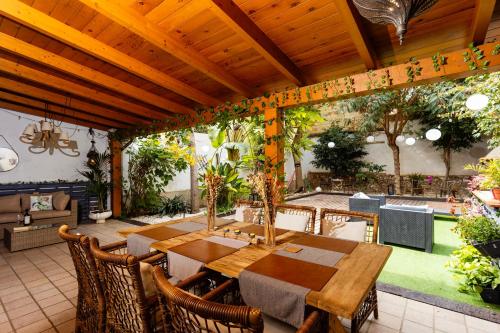 een eetkamer in de openlucht met een tafel en stoelen bij Portrait Boutique Guesthouse in Valencia