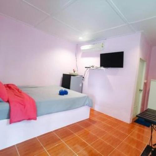 a bedroom with a bed and a tv on a wall at PRAKAI RESORT in Ban Don Klang