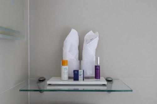 a glass shelf with towels and toiletries in a bathroom at The Goudhurst Inn in Goudhurst