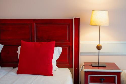 a red bed with a red headboard and a red pillow at O Cantinho da Mariazinha by Amazing Madeira in Funchal