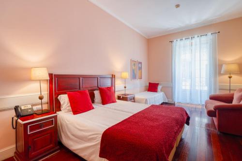 a bedroom with a large bed with red pillows at O Cantinho da Mariazinha by Amazing Madeira in Funchal