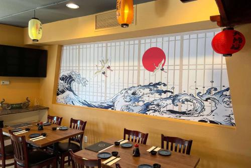 a dining room with a large painting on the wall at La Quinta by Wyndham San Francisco Airport West Millbrae FREE AIRPORT SHUTTLE in Millbrae