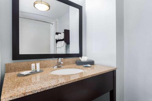 a bathroom with a sink and a large mirror at La Quinta by Wyndham Bonita Springs Naples North in Bonita Springs