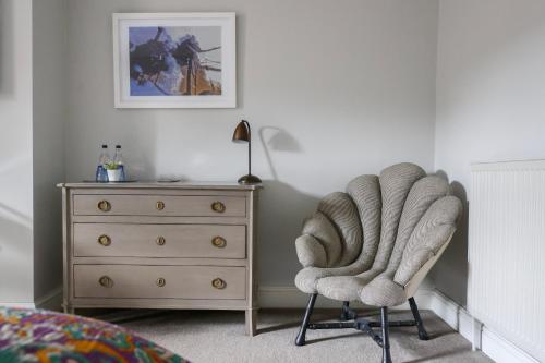 a bedroom with a dresser and a chair and a bed at The Goudhurst Inn in Goudhurst