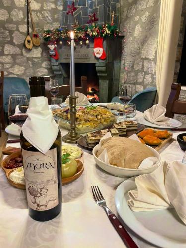 a table with plates of food and a bottle of wine at Bujtina Adora in Ara të Lumit