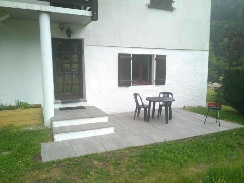une terrasse avec une table et des chaises devant une maison dans l'établissement Le regit, Studio moderne Balneo, à La Bresse