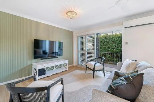 a living room with a couch and a tv at Budds Villa 2 By Khove in Gold Coast
