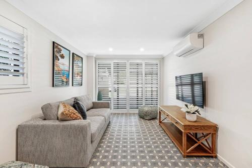 a living room with a couch and a table at Budds Villa 2 By Khove in Gold Coast