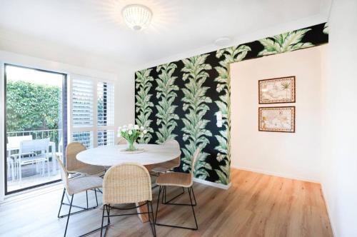 a dining room with a table and chairs and a wall mural at Budds Villa 2 By Khove in Gold Coast
