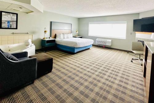 a hotel room with a bed and a bath tub at AmericInn by Wyndham Shakopee Near Canterbury Park in Shakopee