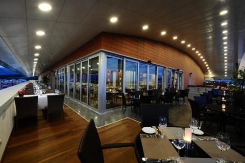 a restaurant with tables and chairs and windows at Ramada by Wyndham Podgorica in Podgorica