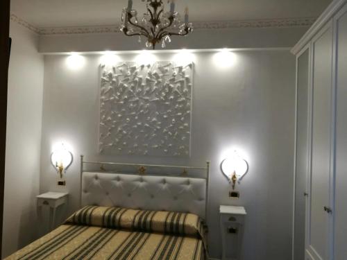 ガリポリにあるGallipolitravel Sand Apartmentのベッドルーム1室(シャンデリアと2つの照明付きのベッド1台付)