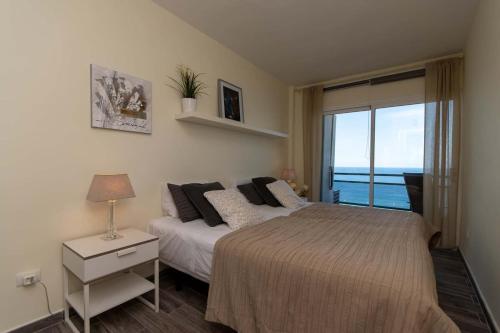 a bedroom with a bed with a view of the ocean at Comodoro 6 - One Bed in Los Cristianos
