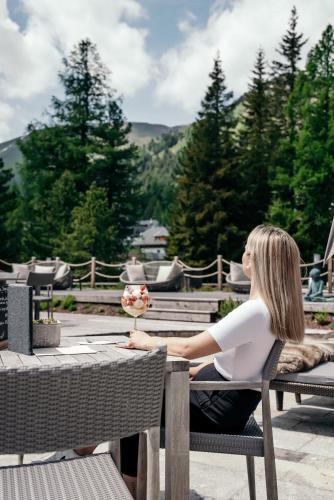 a woman sitting at a table at a table at Hotel Hochschober in Turracher Hohe